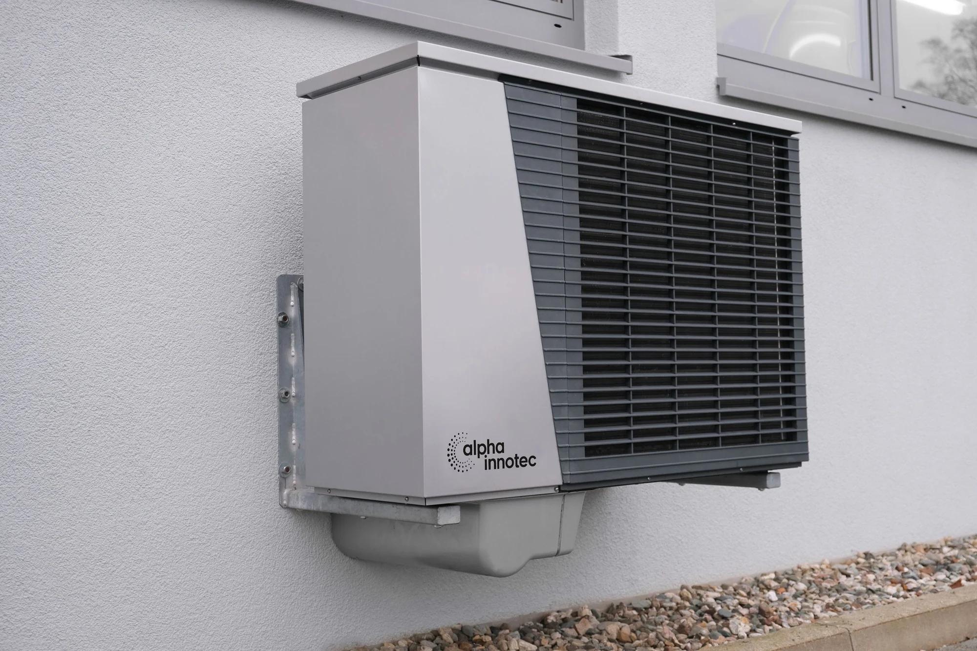 Outdoor air conditioning and heating unit beside a home